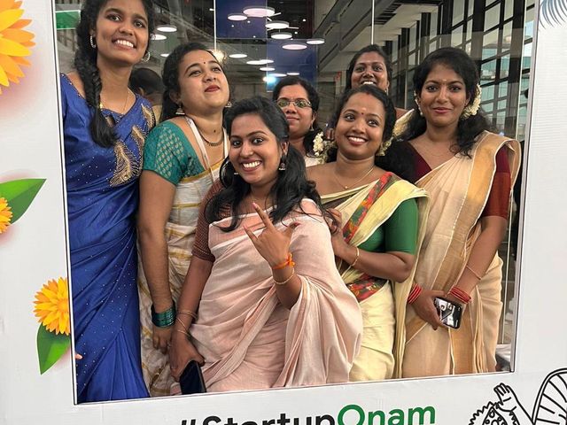 A group in Kerala sarees at the StartupOnam photo frame